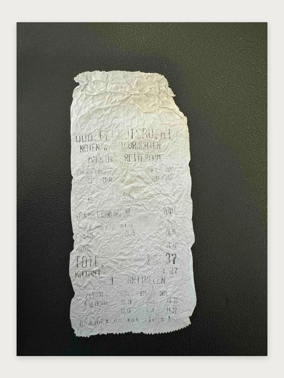 Crumpled, faded thermal receipt from Rotterdam where the shop name and most amounts are unreadable